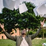 Excited male student throwing university papers in air